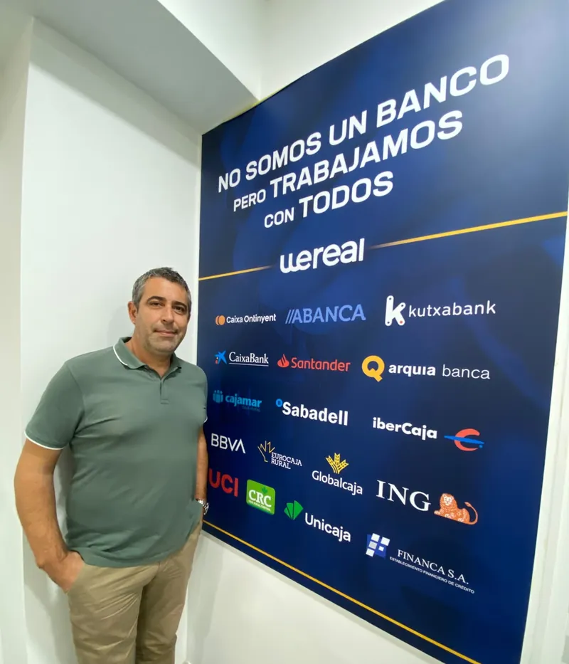 Andrés Broullón junto al panel «No somos un banco pero trabajamos con todos» de Wereal con las entidades financieras colaboradoras Andrés Broullón junto al panel «No somos un banco pero trabajamos con todos» de Wereal con las entidades financieras colaboradoras